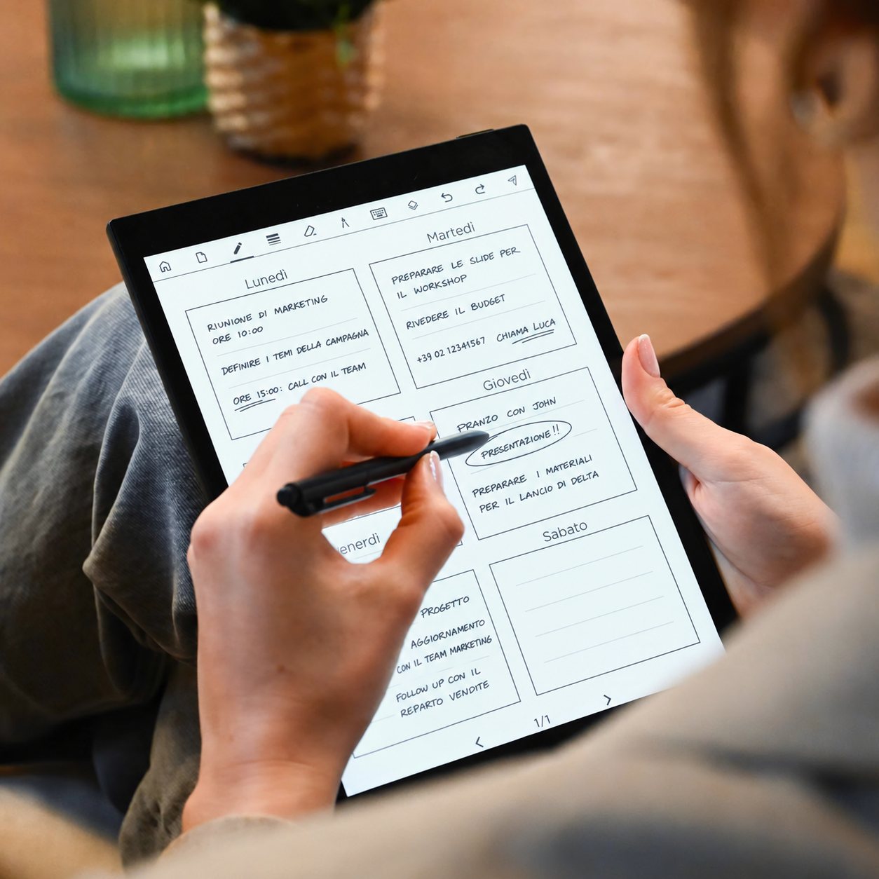Una donna scrive il planner settimanale su notando Pro con la penna